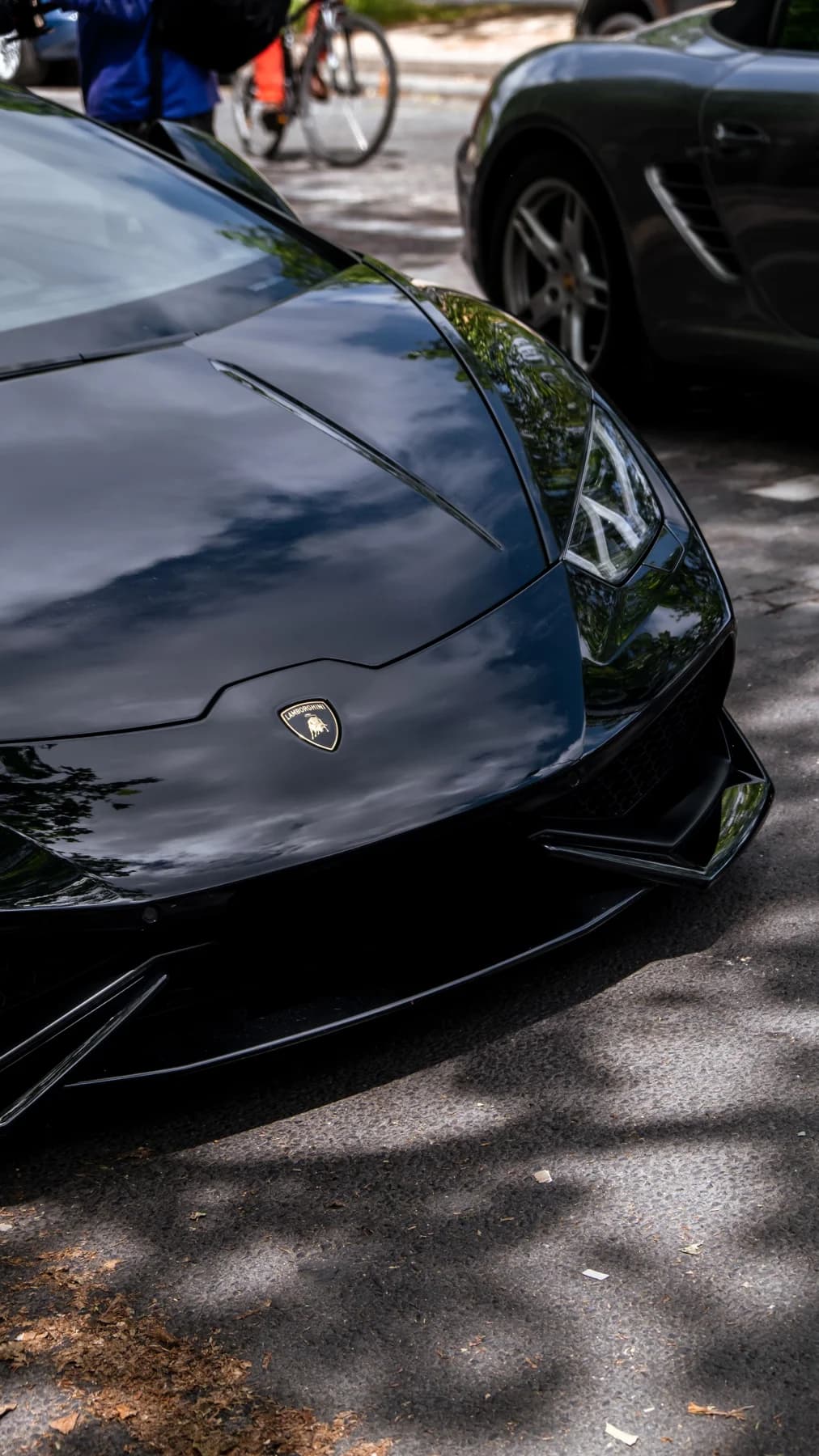 Glossy black Lamborghini with reflections across its hood